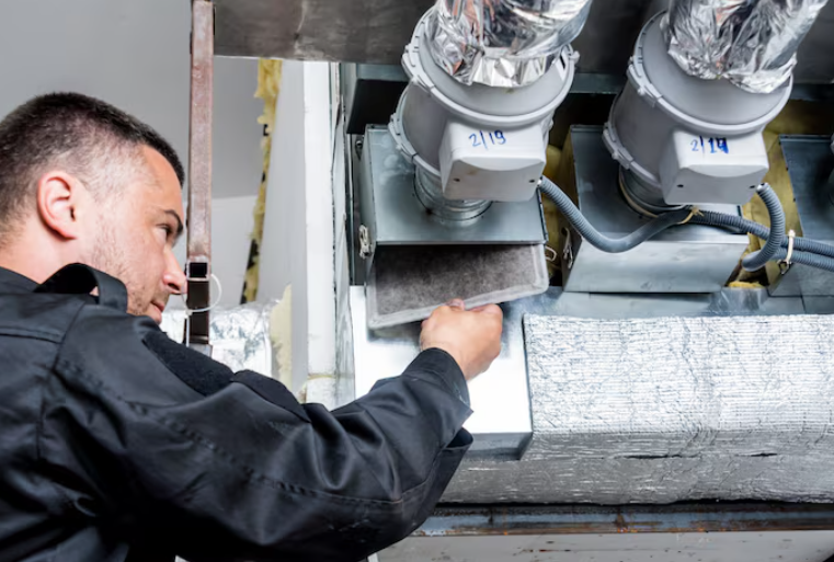 technician working on HVAC vent cleaning